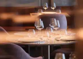 Ein runder Tisch mit sorgfältig arrangierter Tischwäsche für vier Personen steht im Restaurant des Hotels LOISIUM Champagne.