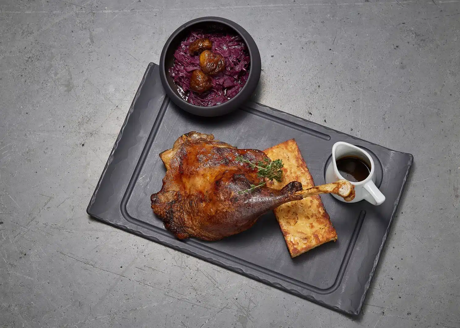 Martinigans angerichtet auf Schieferplatte mit Rotkraut und Polenta
