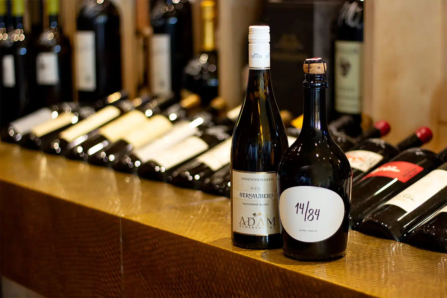 zwei Weine werden auf dem goldenen Vinothekstisch präsentiert